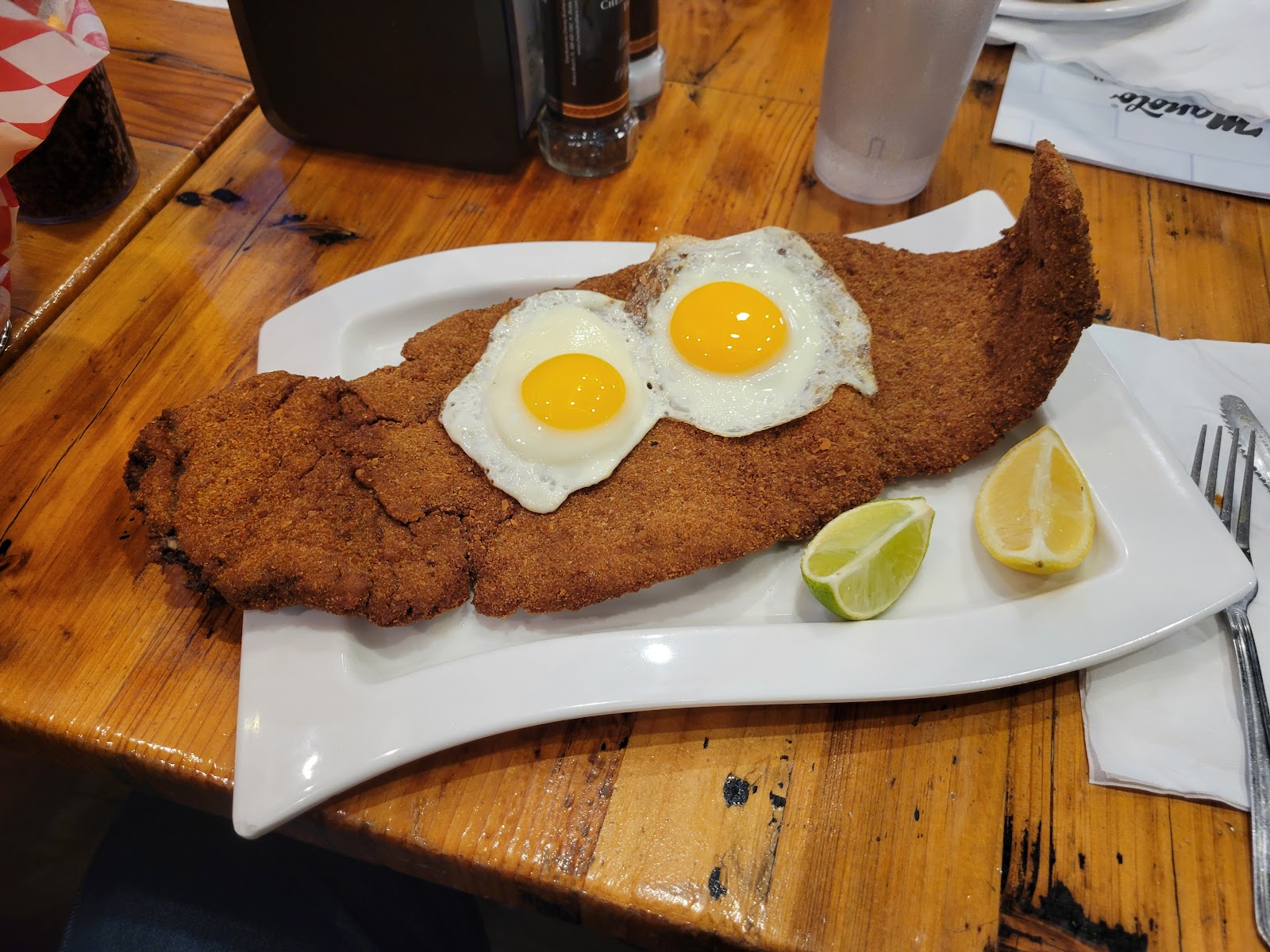 Breaded steak with eggs and lime
